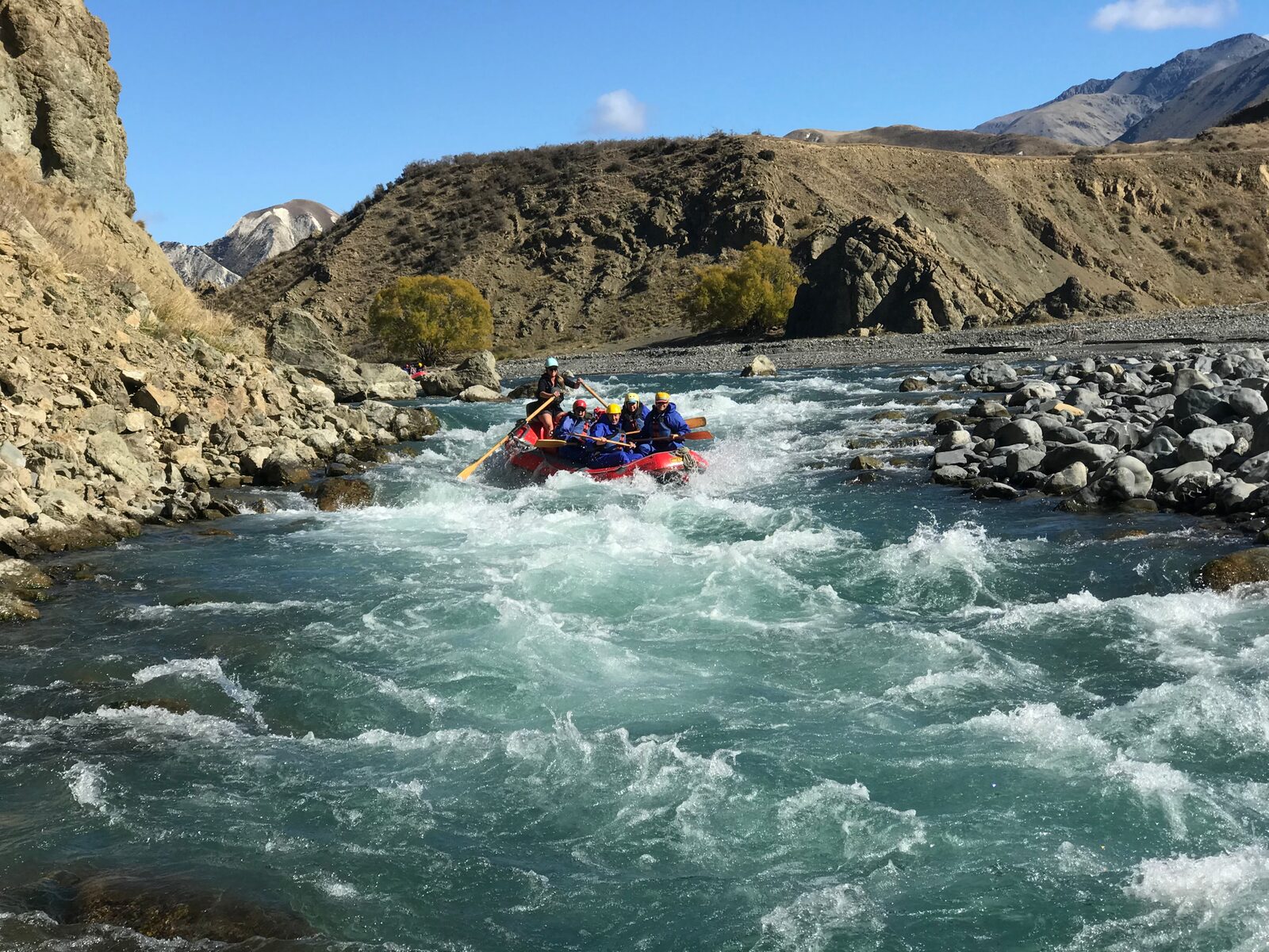 A raft punching through whitewater rapids in a remote gorge